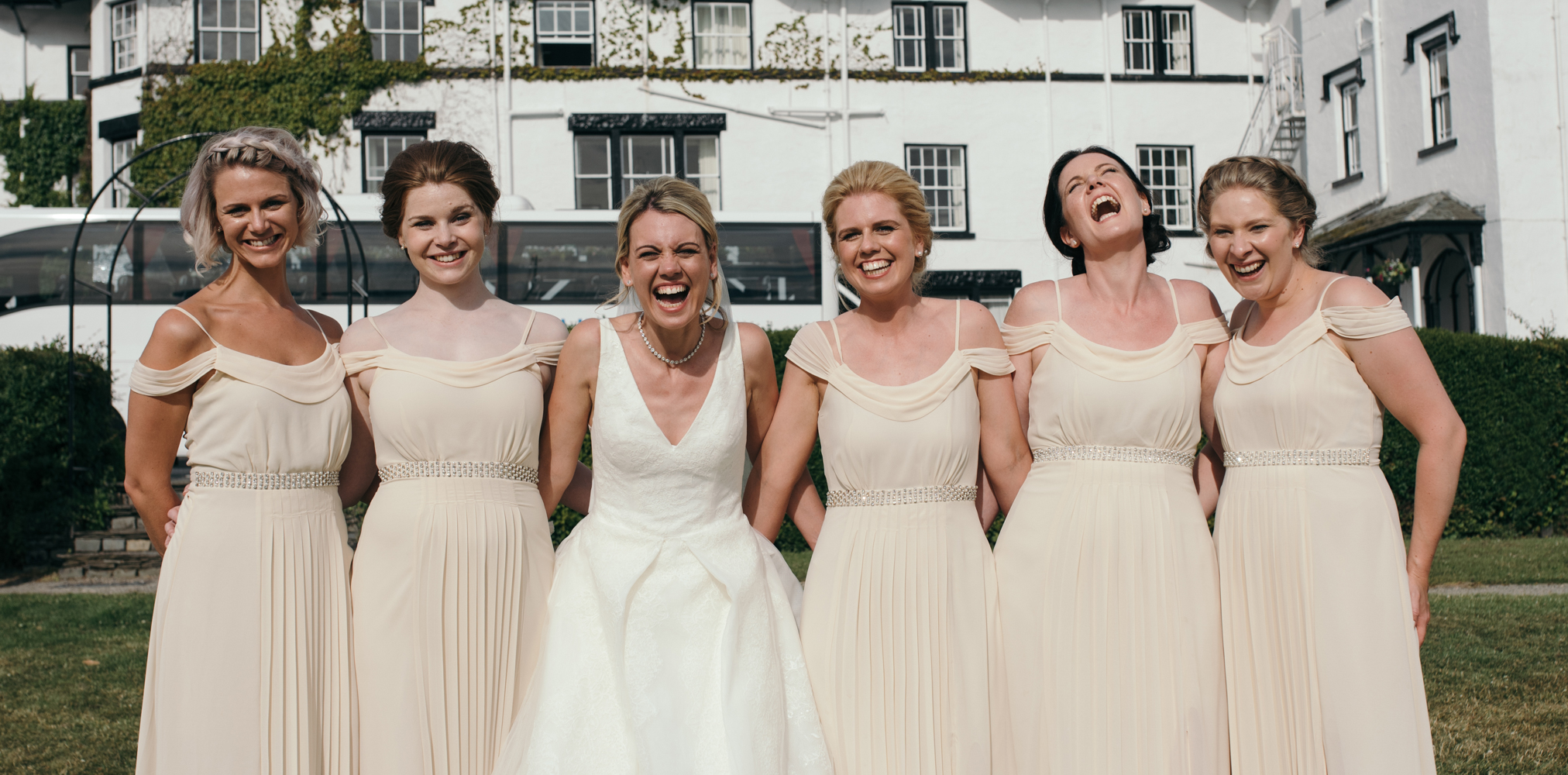 The bride and bridesmaids goofing around during the family group shots