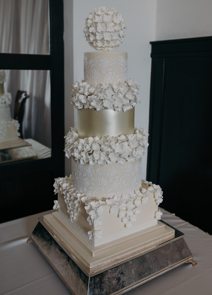 A photo of the amazing wedding cake on its stand in the wedding breakfast room