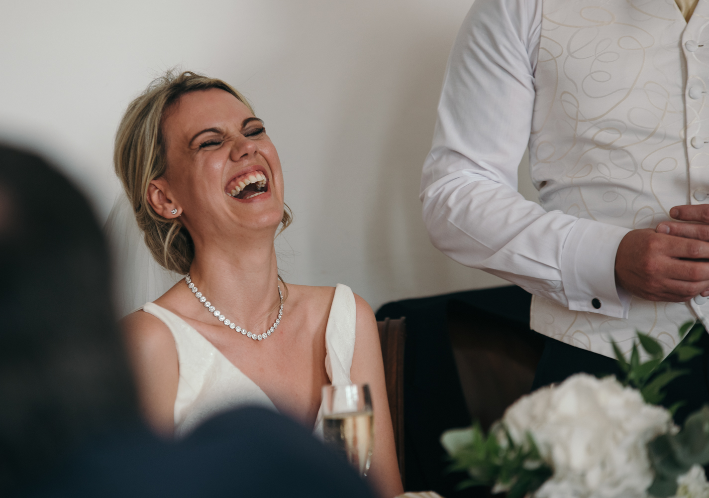 The bride laughing during the grooms speech