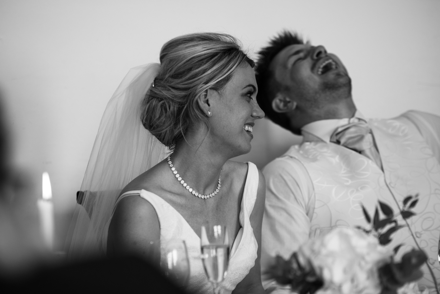 the bride and groom laughing during the best mans speech