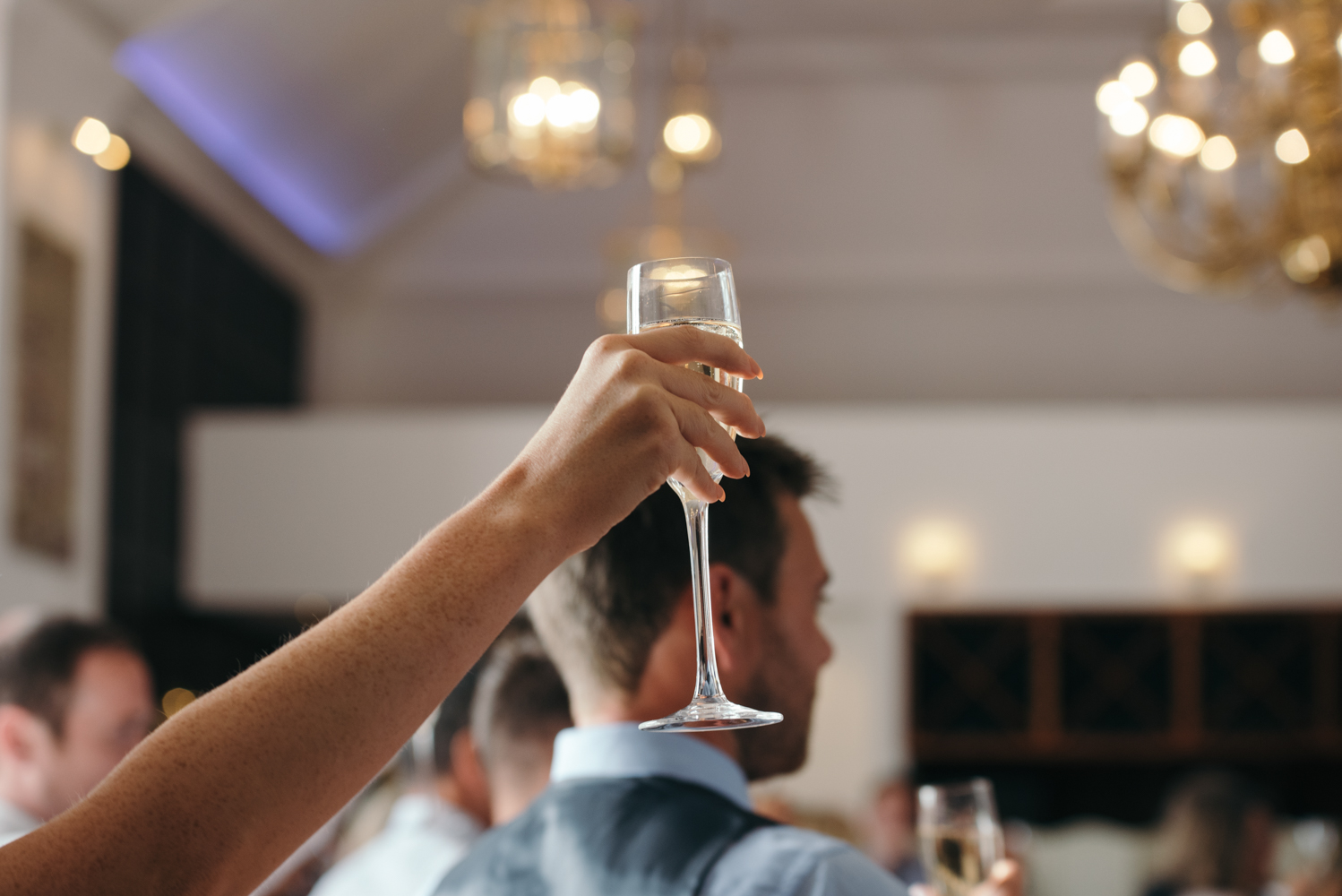 A guest holds up a champagne glass at the end of the speeches