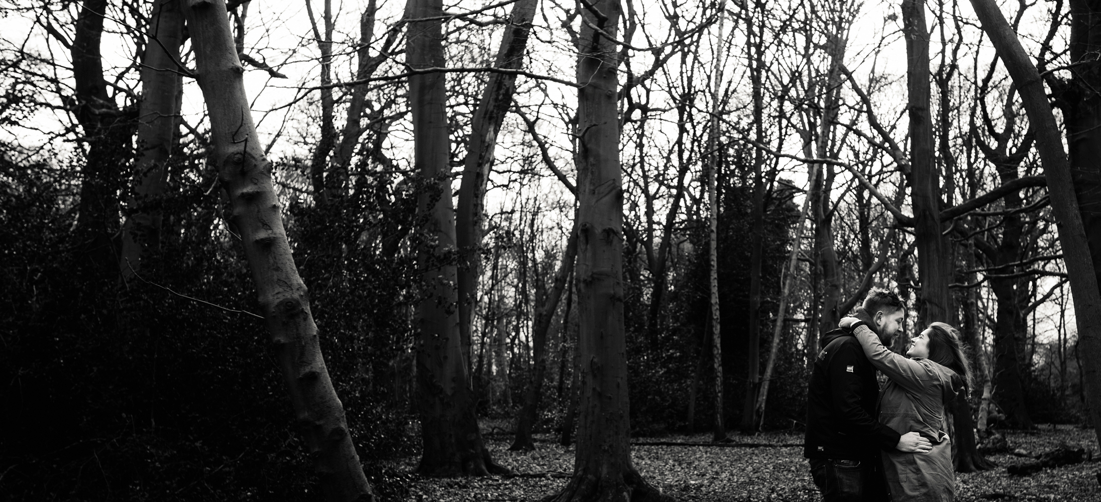 Pre shoot A black and white photo of a couple in the woods hugging