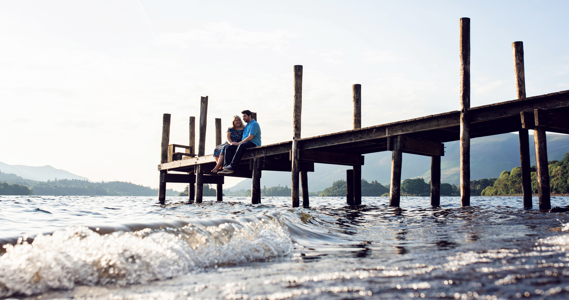 Pre shoot - A couple sitting on the pier at Ashness Bridge on the shores of Derwent water in the Lake District