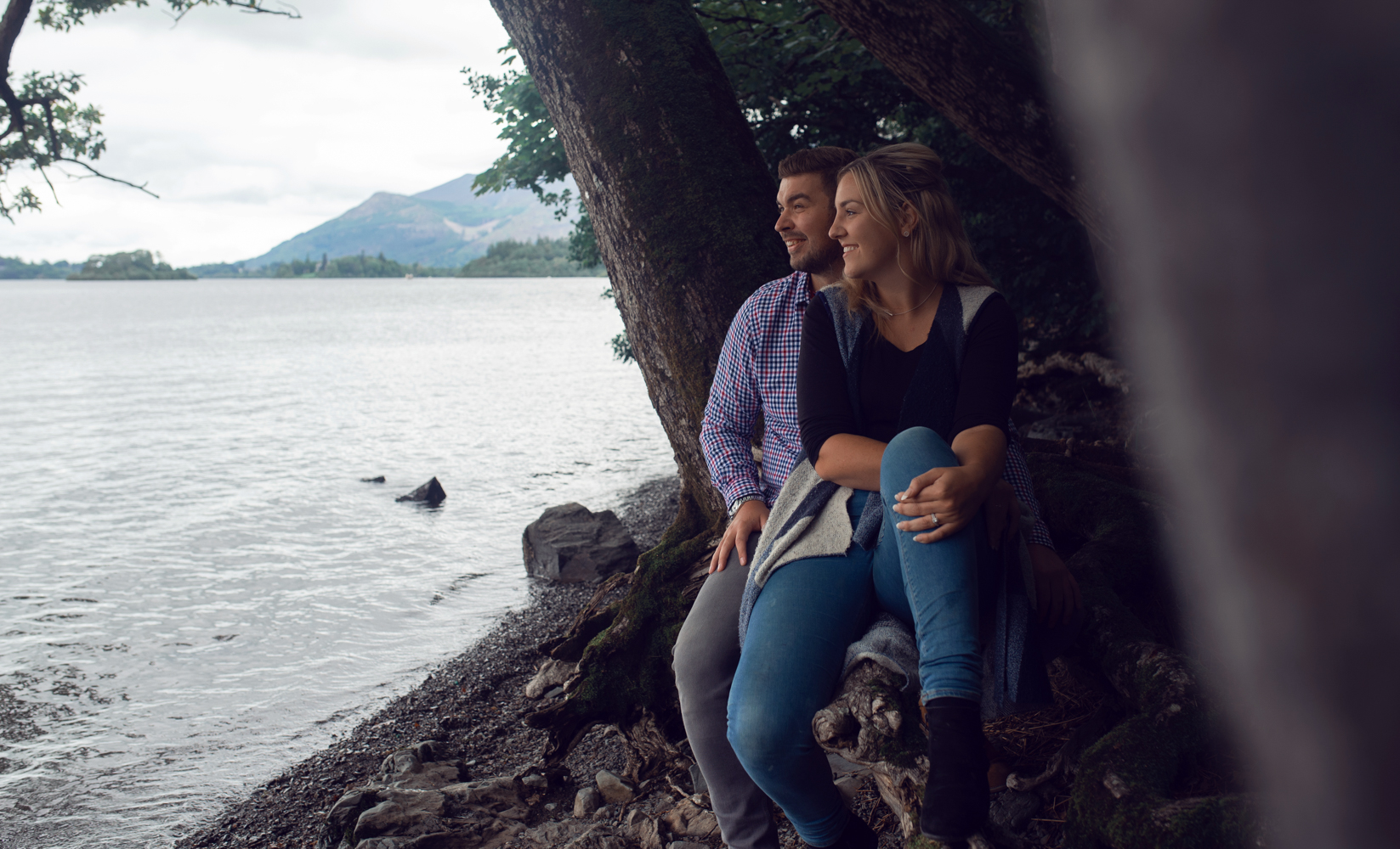 Pre shoot - A couple sitting on a fallen log on the shores of Derwent water in the Lake District