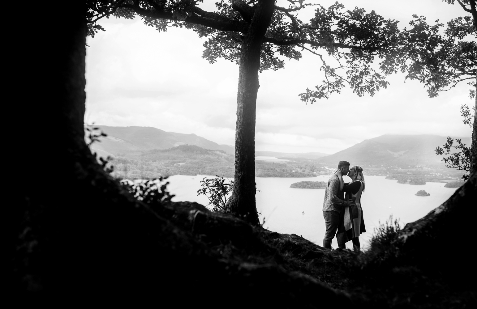Pre shoot - A couple standing in between two trees with the lake in the background