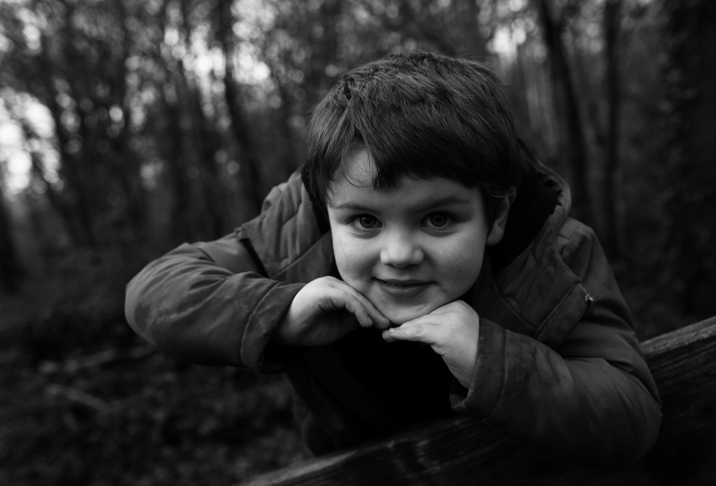 A black and white portrait of young lad in the woods