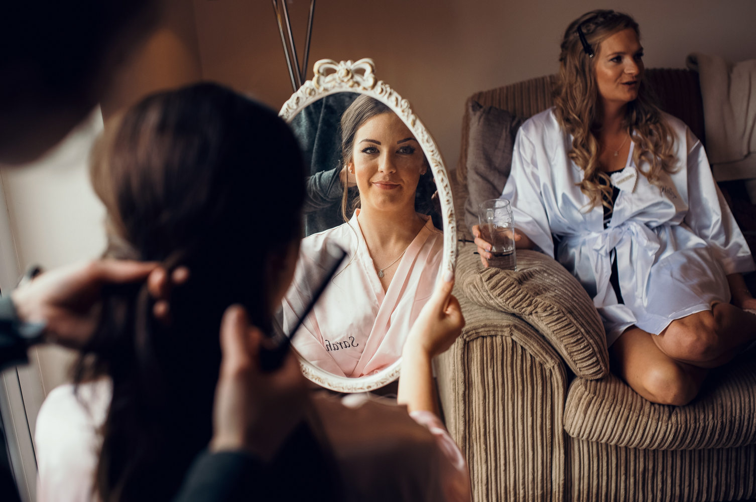 A bridesmaid having her hair styled during morning bridal preparations