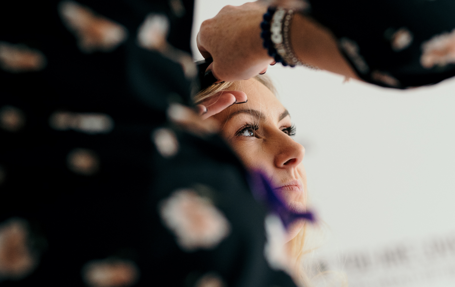 A bridesmaid having her hair and makeup done during morning bridal preparations