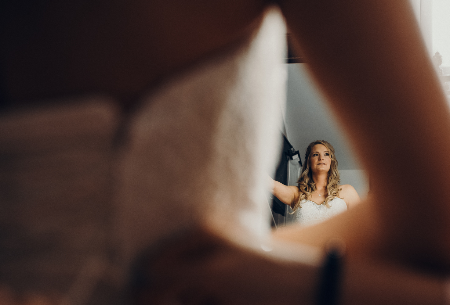 A photograph of a bride taken in the dressing mirror during bridal preparations