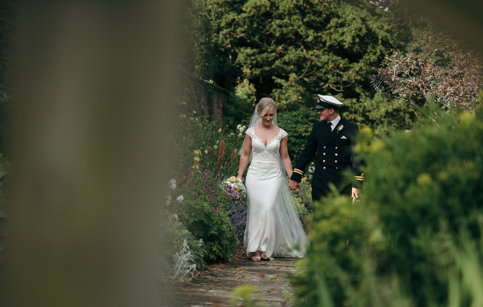 The bride and groom walking in the secret garden