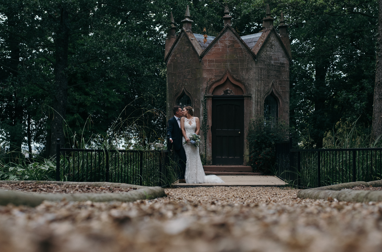 A bride and groom kissing near the old pumping station