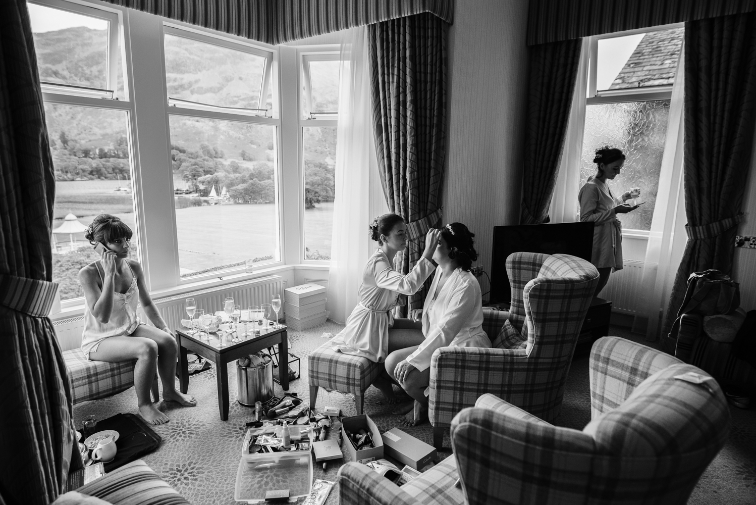 Black and white wide angle photo of bridal preparations with the lake district mountains in the background