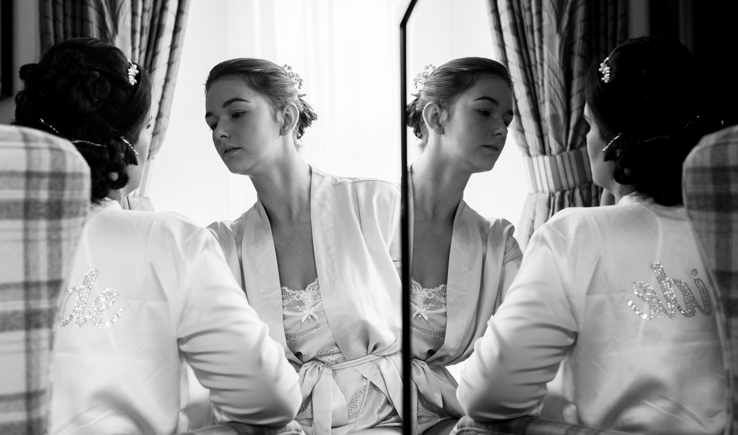 Bride having her makeup applied with a reflection in a tv screen