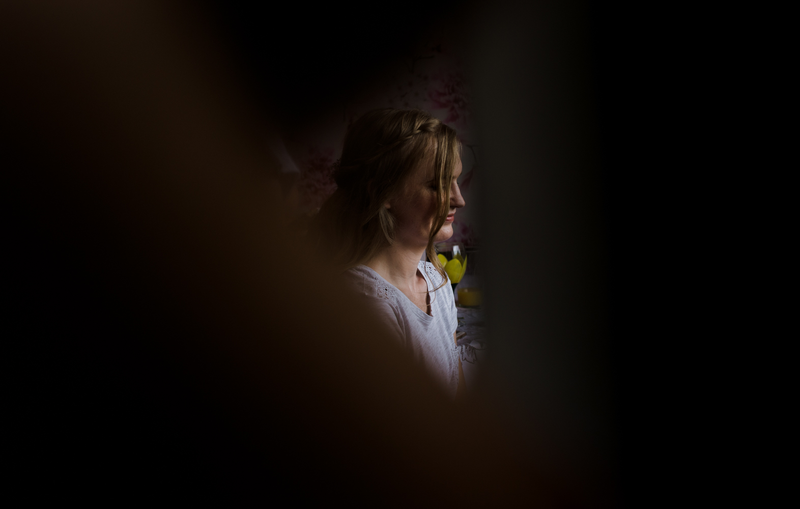 A moody photo of one of the bridesmaids during preparations