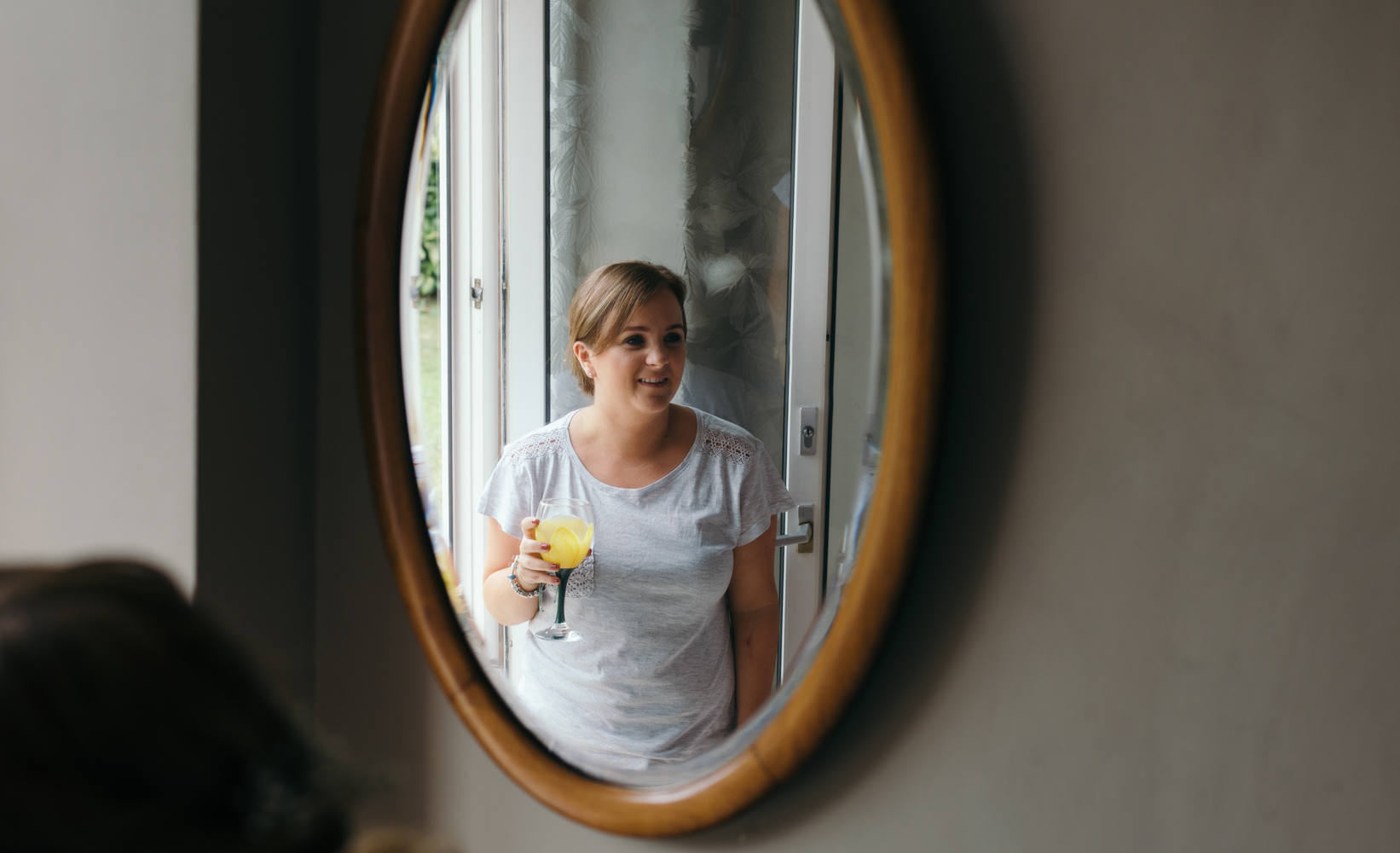 A bridesmaid enjoying a drink during preparations