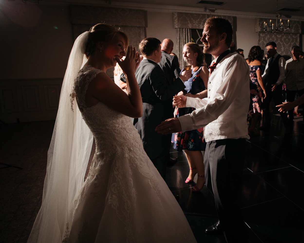 The bride and groom messing around and having a good laugh on the dance floor