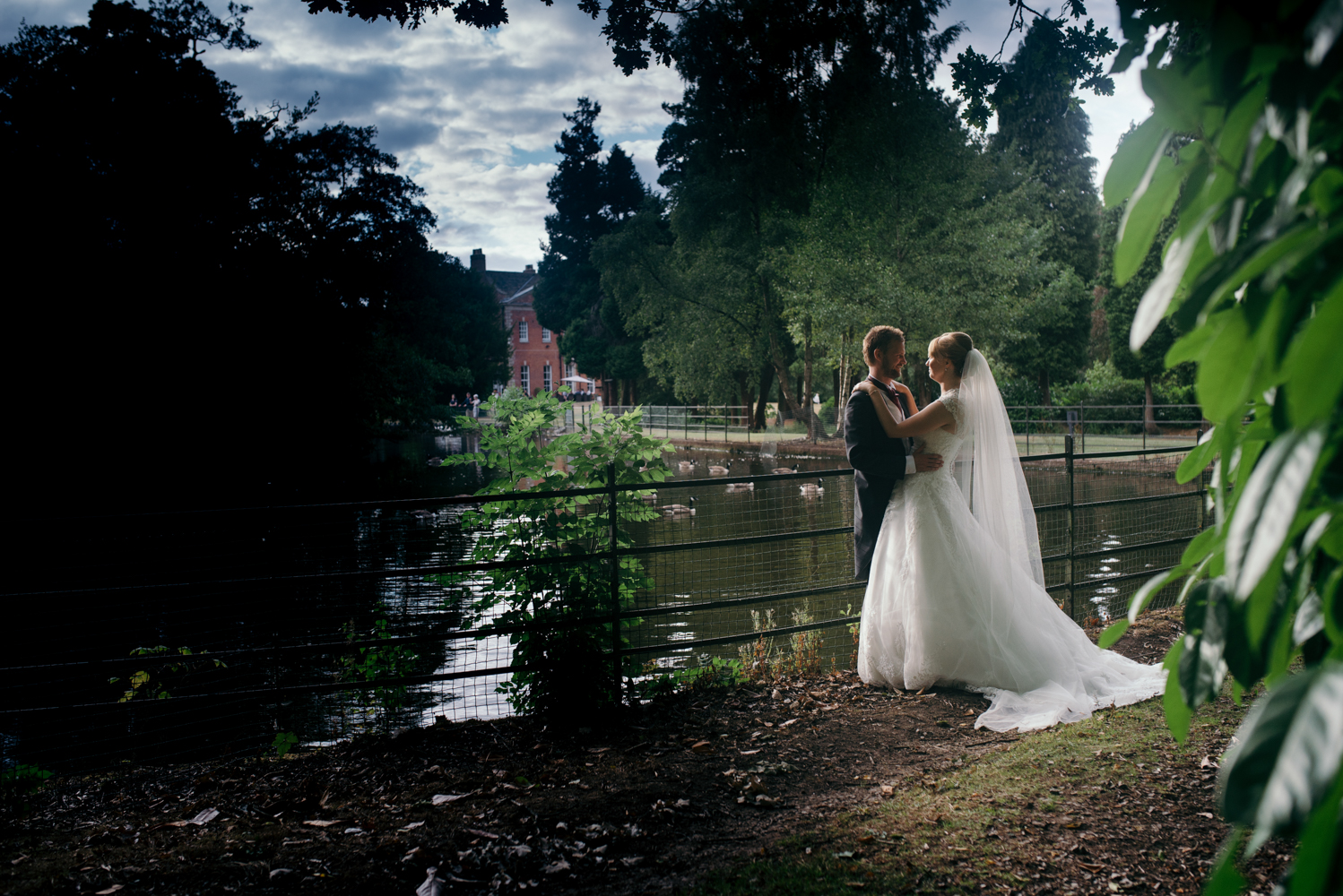 Romantic photo of the happy couple standing at the side of the lake at Motram Hall Hotel