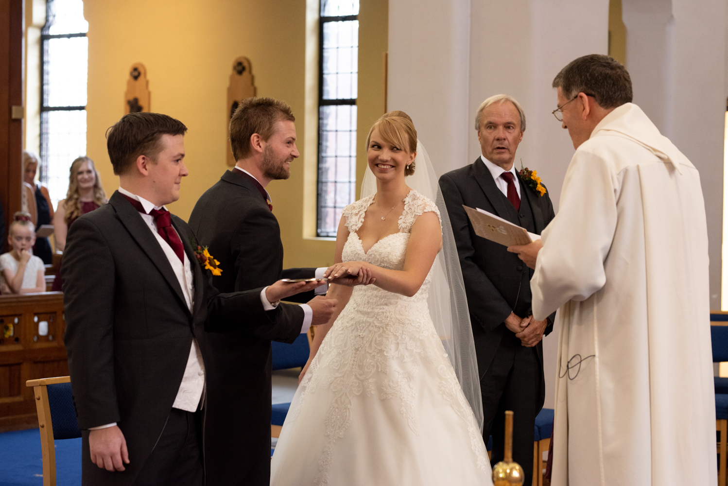 The bride and groom have a laugh during the exchange of wedding rings