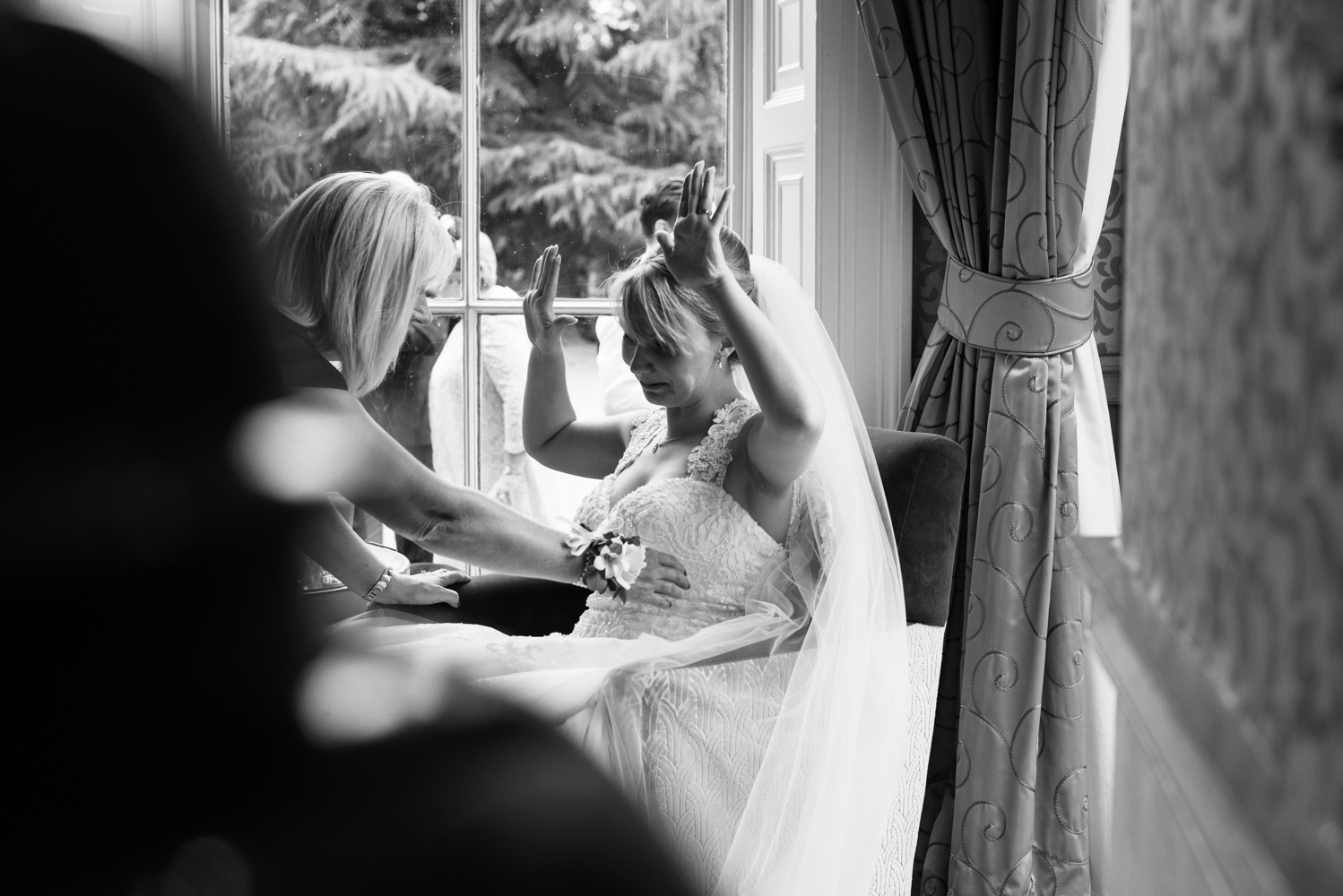 A black and white photo of the bride relaxing during the drinks reception