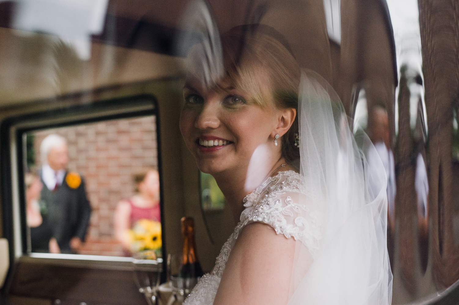 The bride sitting in the back of the car as she arrives at church