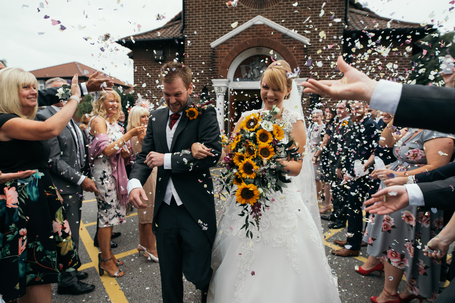 A bride and groom being showered in confetti