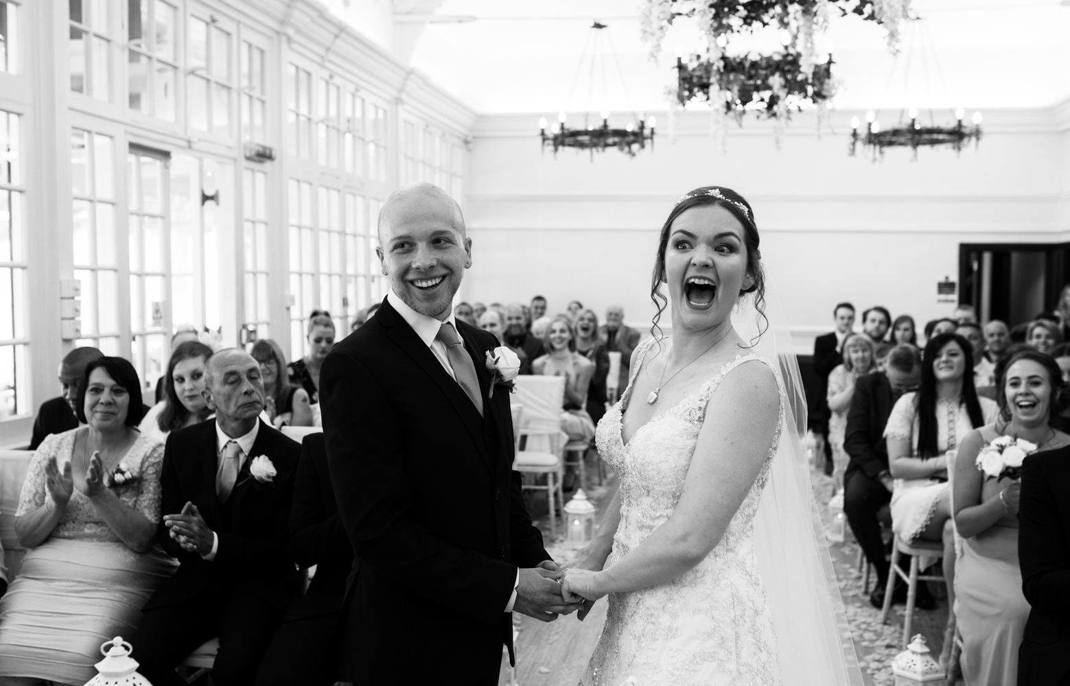 A black and white image of the bride and groom just as the groom says I do