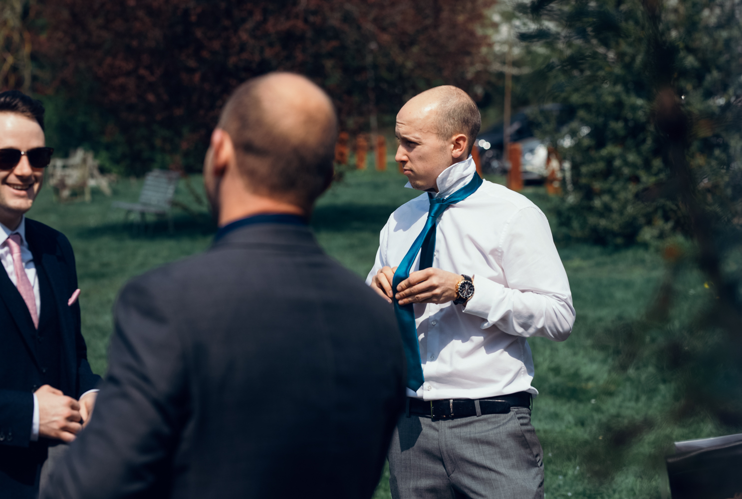 One of the male guests outside putting on his tie