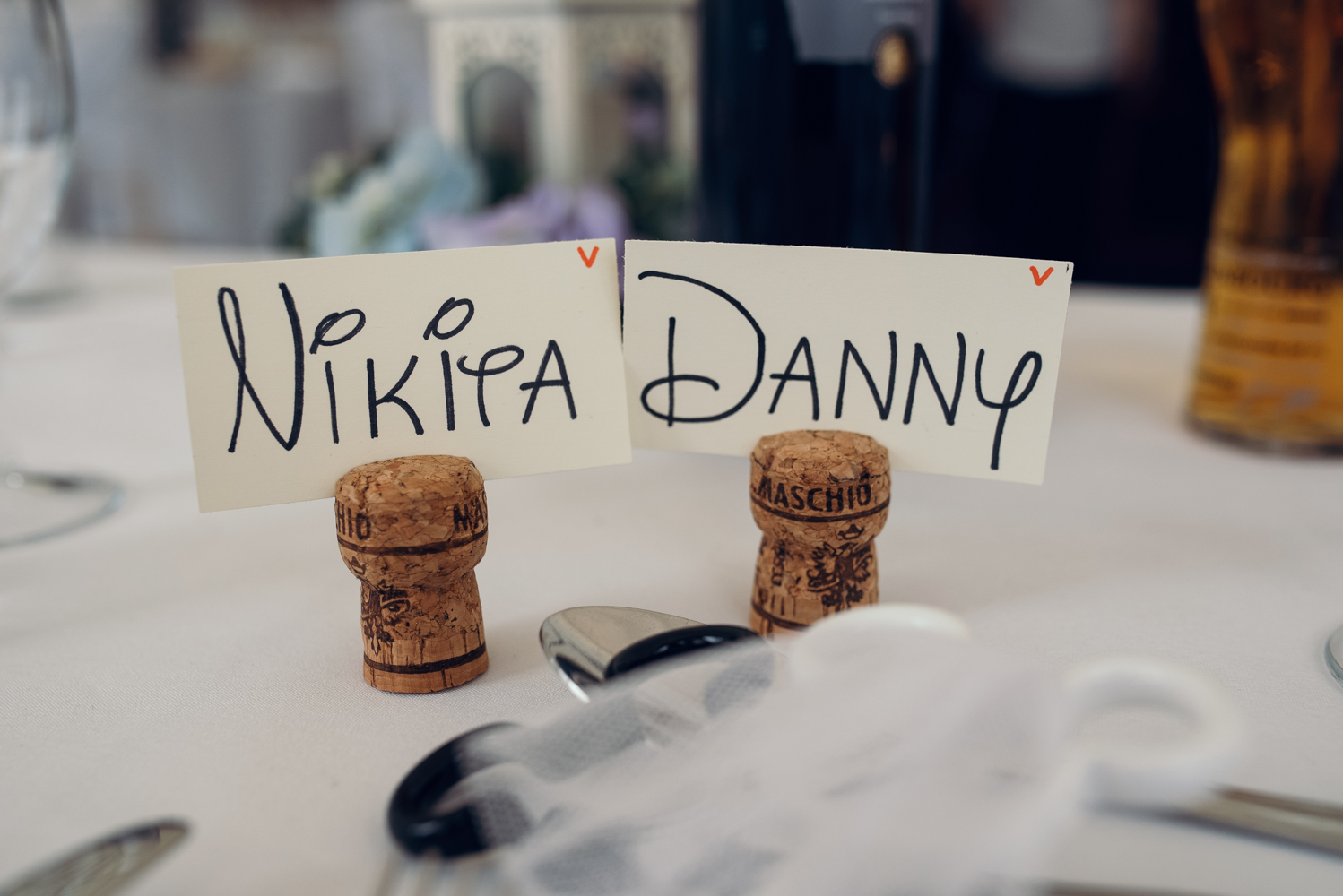 The bride and grooms names in corks used as place settings on the top table