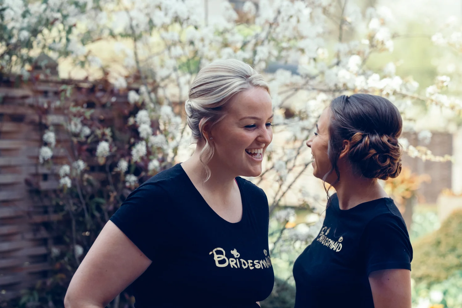 Two bridesmaids having a good laugh outside in the garden