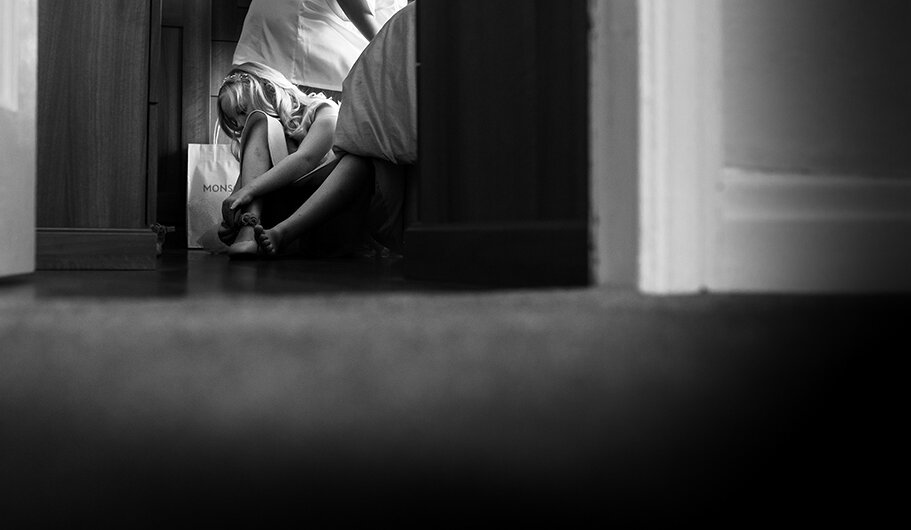 A flower girl putting her shoes on