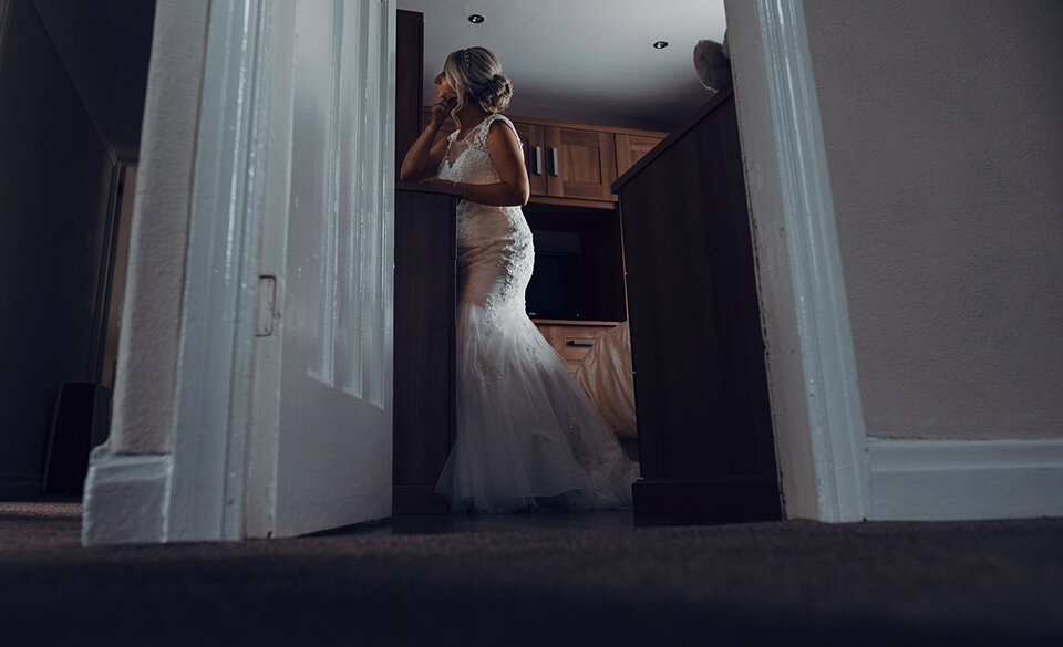 Wide angle shot of the bride putting on her earings