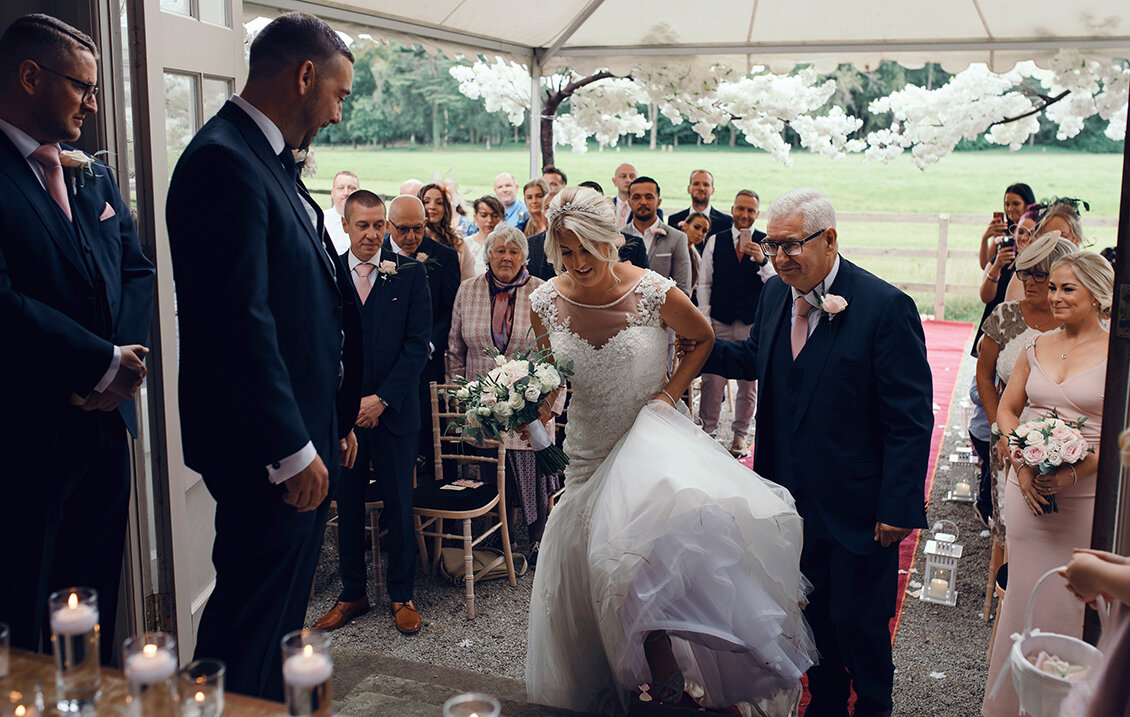 The bride and her father arriving at the top of the aisle 