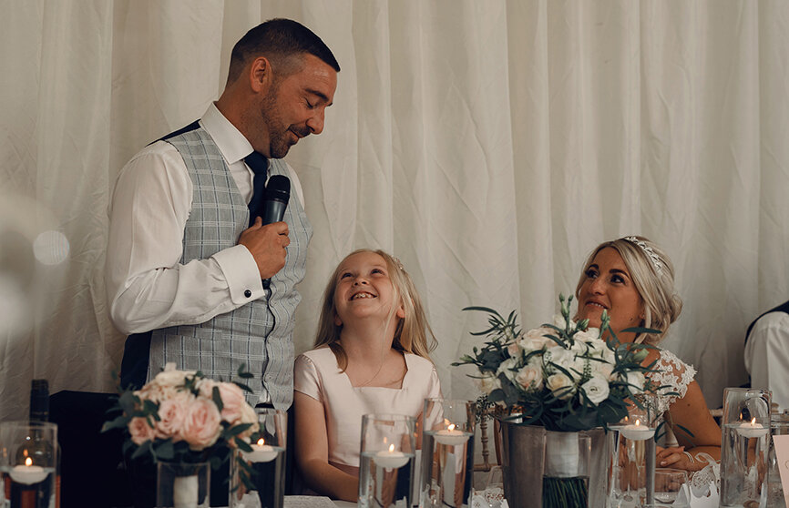 The groom making his speech being watched by one of the flower girls