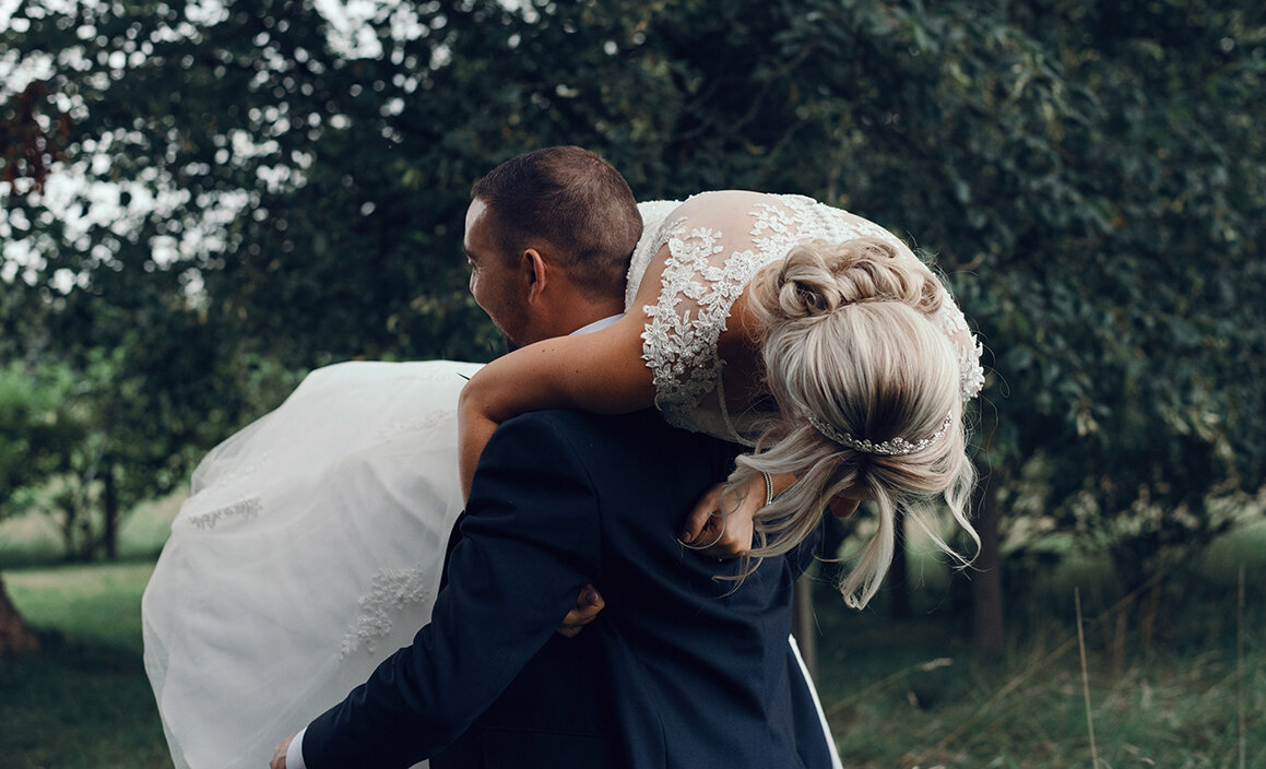 The groom carrying the bride on his shoulder