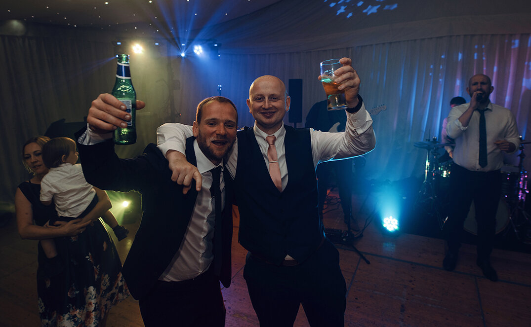 Two of the male wedding guests goofing about on the dance floor