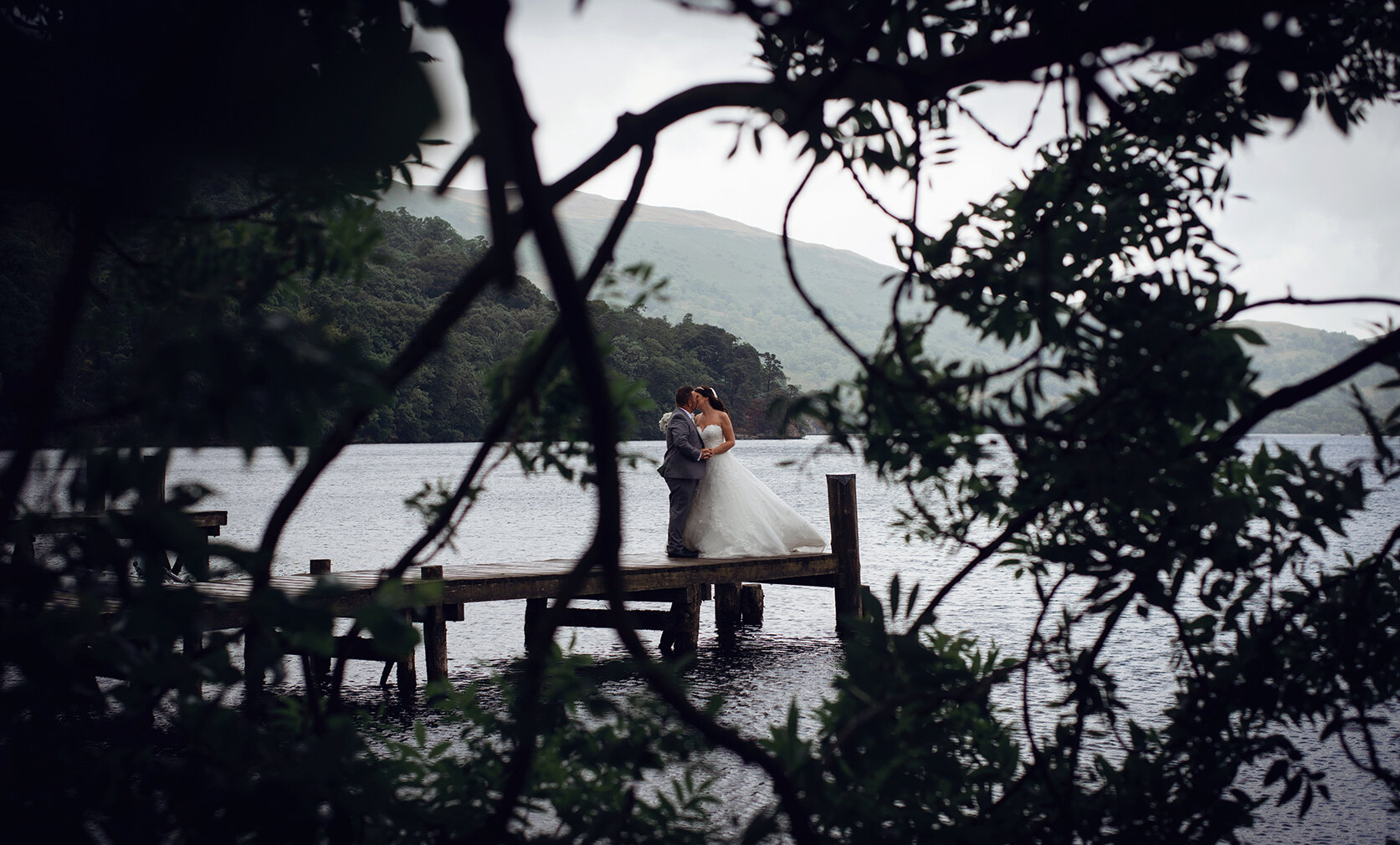 The bride and groom standing on the jetty
