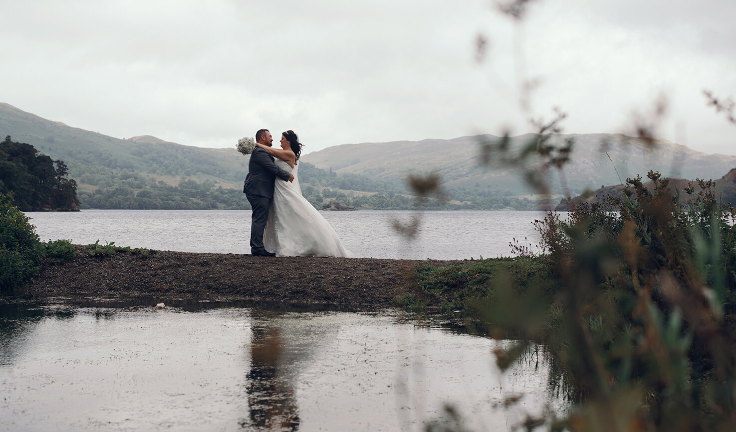 The bride and groom standing by the reflection pool