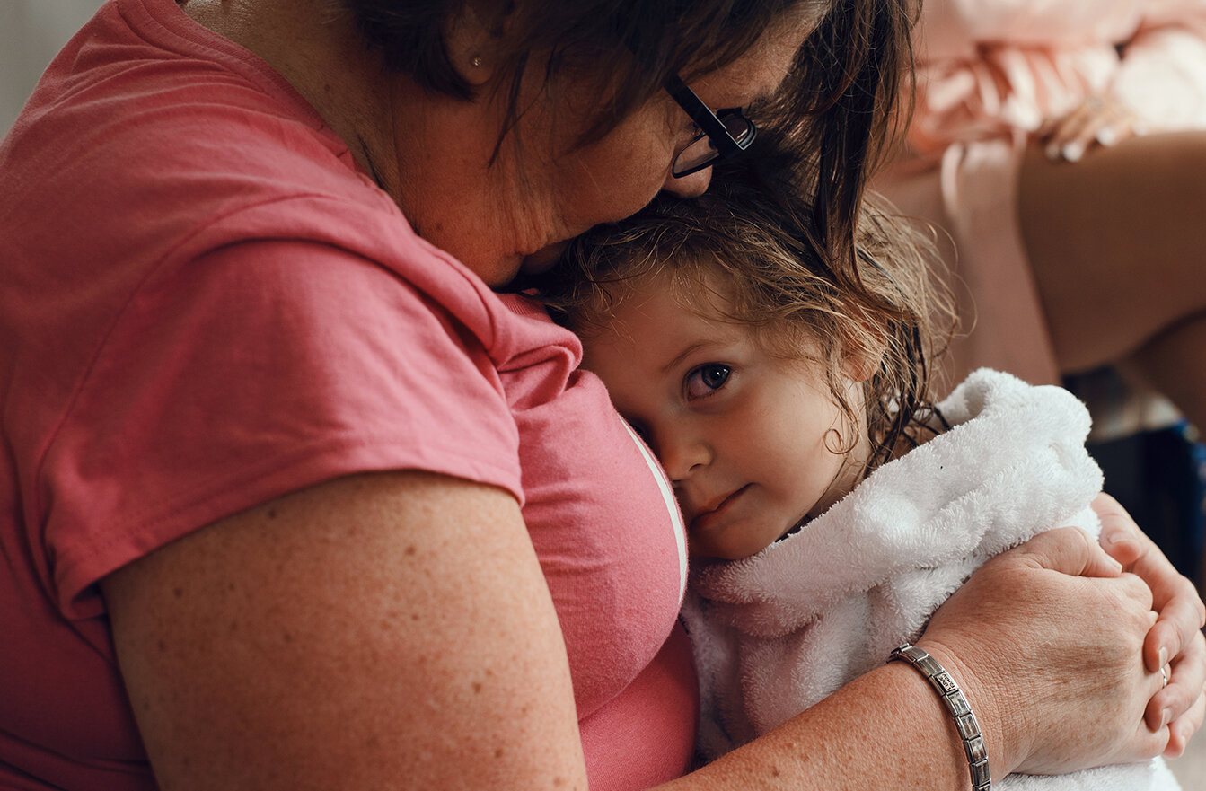 A flower girl having a cuddle with gran