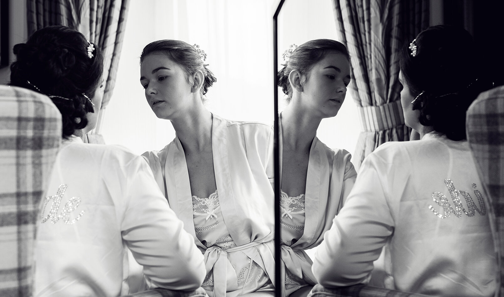 The bride having her makeup done reflected in a tv screen