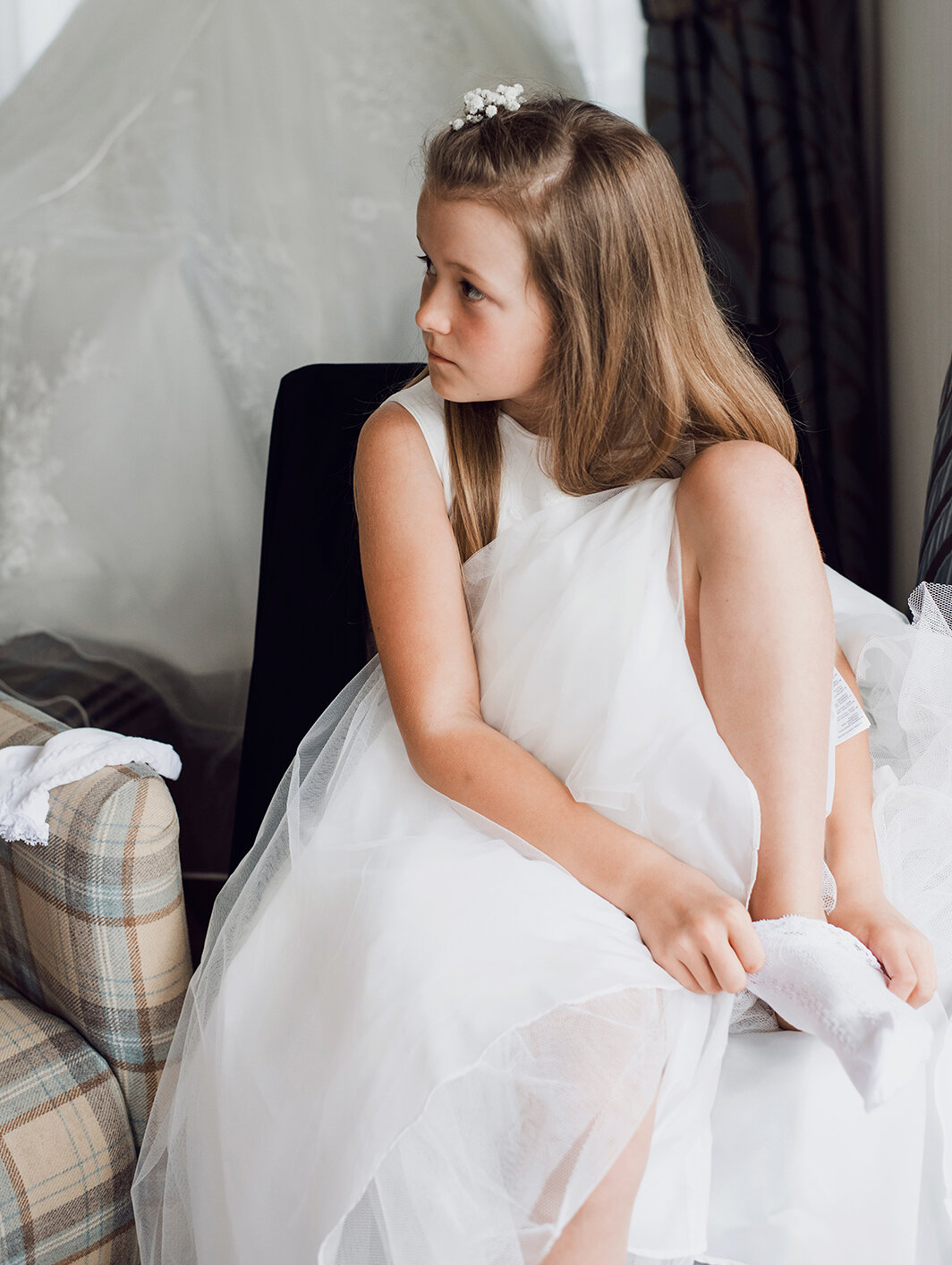 A flower girl putting on her shoes