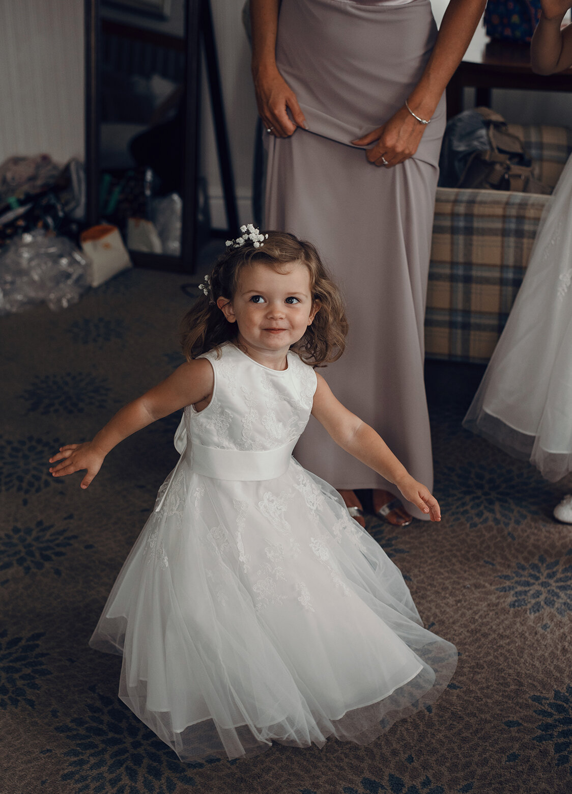 The youngest flower girl doing a twirl in her dress