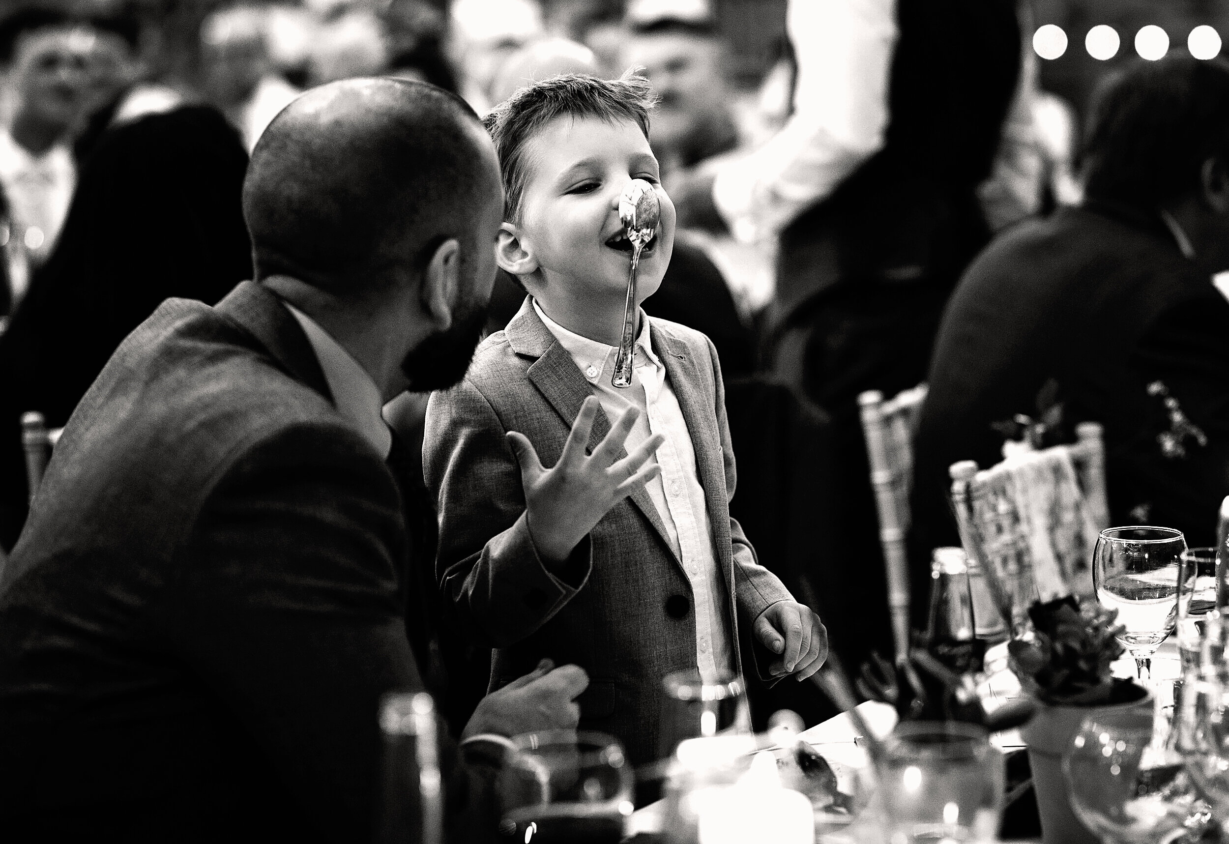A young lad balancing a spoon on his nose during speeches