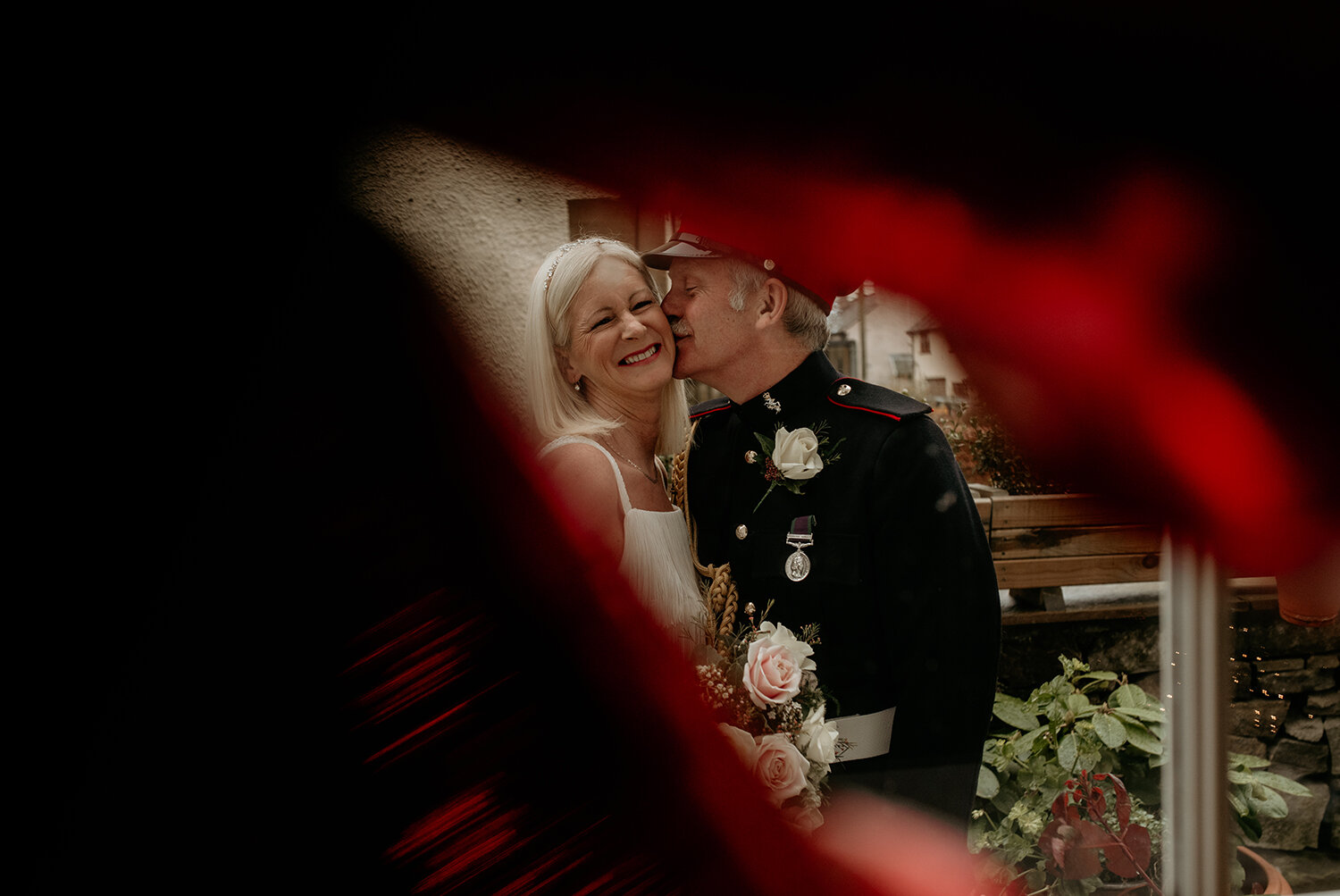 The bride and groom having a cuddle taken through the window