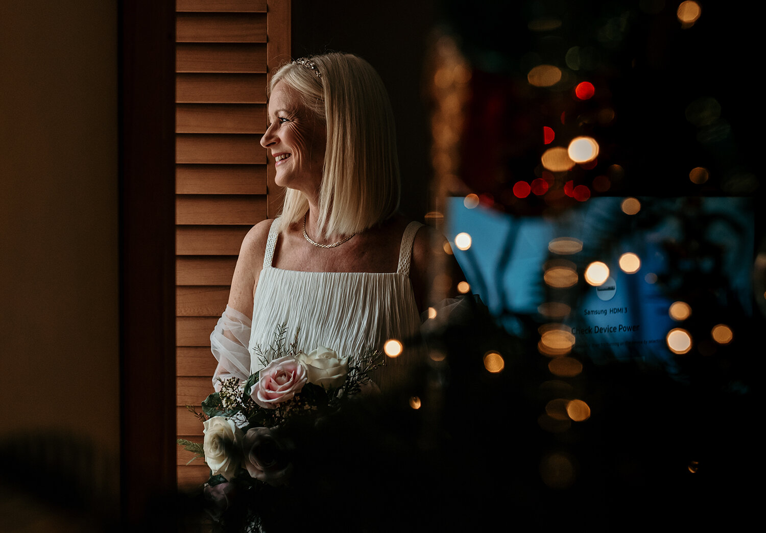 A portrait of the bride looking out of the window with the Christmas tree