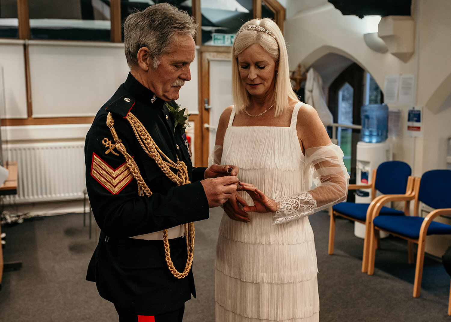 The groom putting the wedding ring on the brides finger