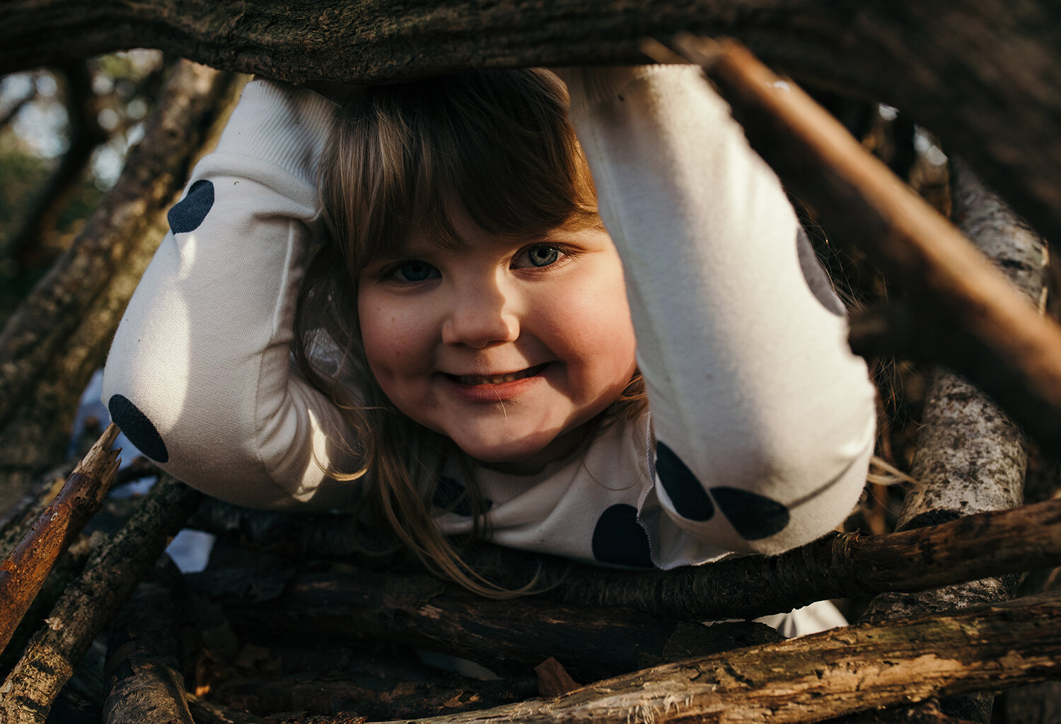 Girl portrait hiding in the fallen twigs