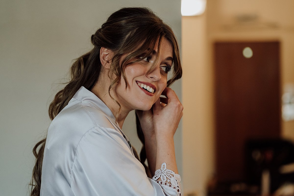 Bridesmaid putting her ear rings in