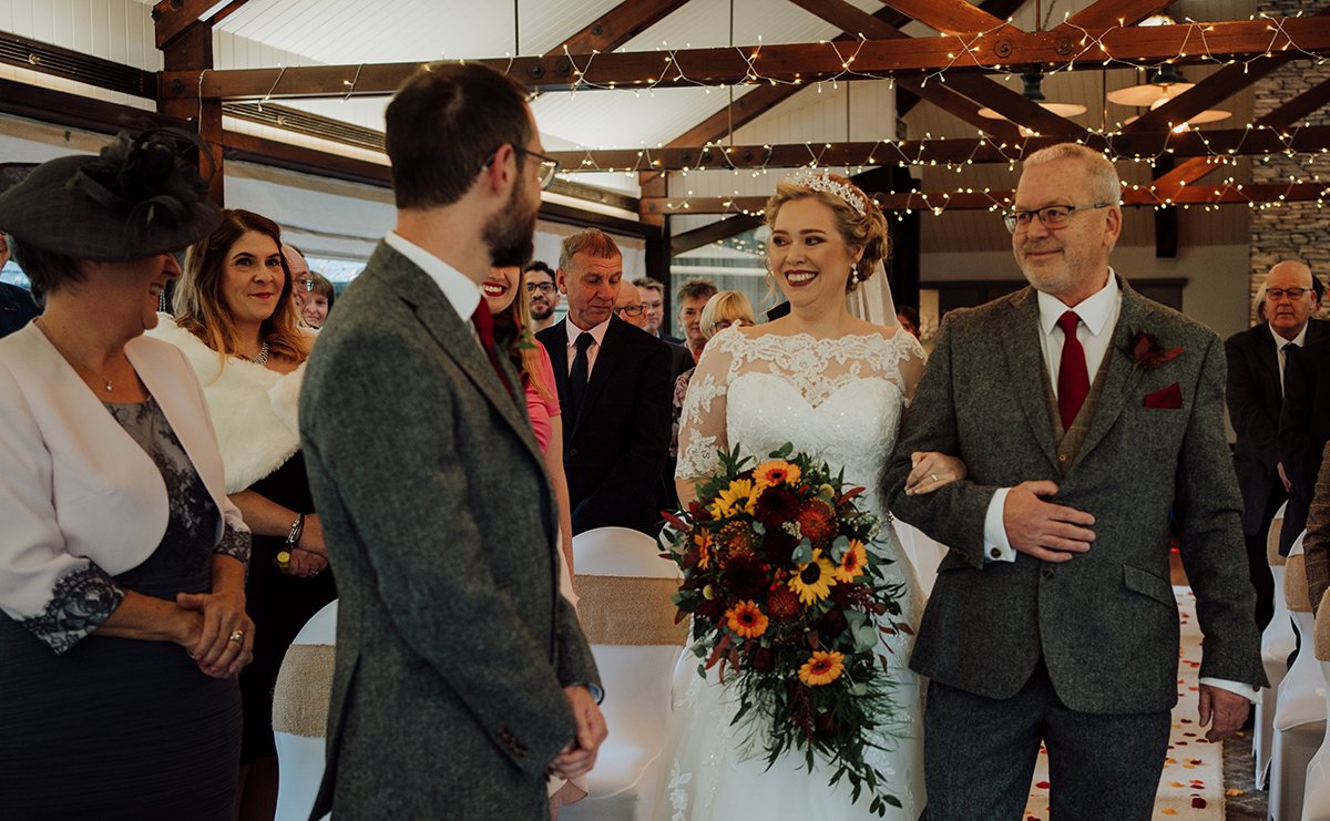 The bride being walked down the aisle by her father