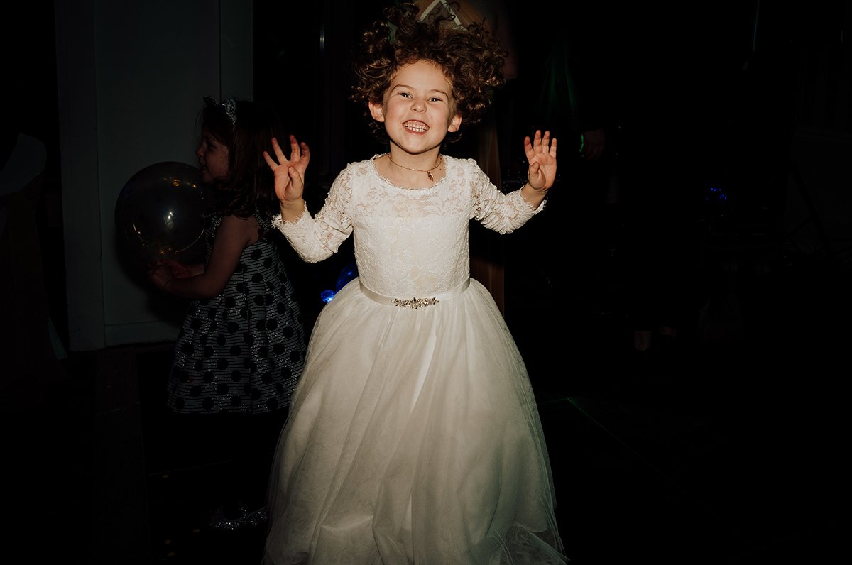 The flower girl on the dance floor during the evening reception