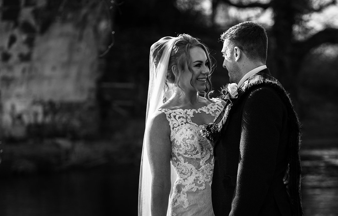 Black and white bride and grooms portrait down by the river